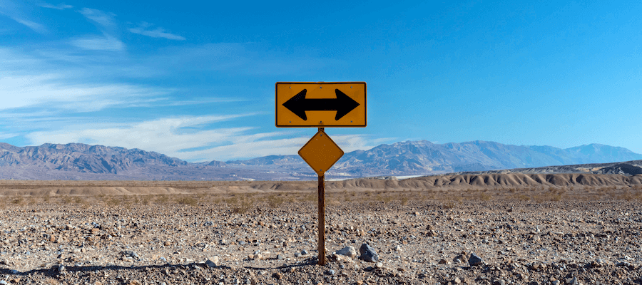 Sign with arrows pointing in opposite directions in the desert.